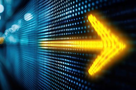 A glowing yellow arrow on a digital LED wall, symbolising progress, direction, and forward movement.
