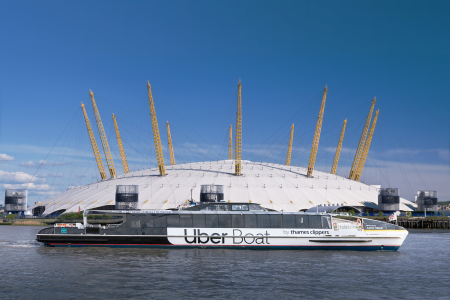 Uber Boat by Thames Clippers vessel traveling along the River Thames in front of the O2 Arena in London.