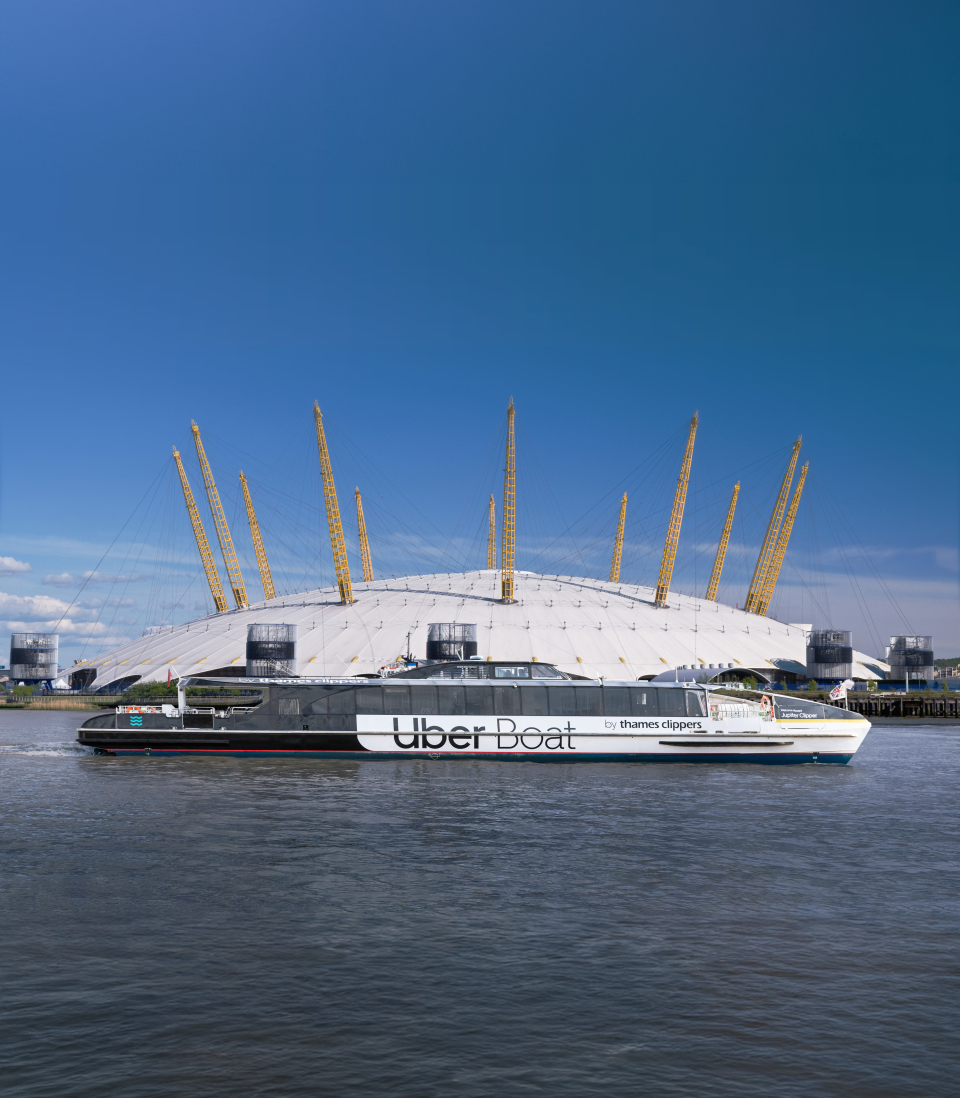 Uber Boat by Thames Clippers vessel traveling along the River Thames in front of the O2 Arena in London.