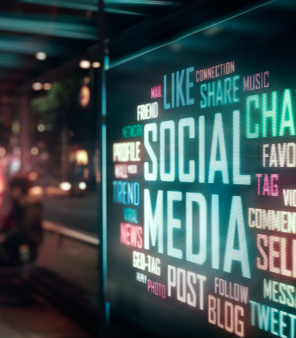 Neon social media words displayed on a city street at night