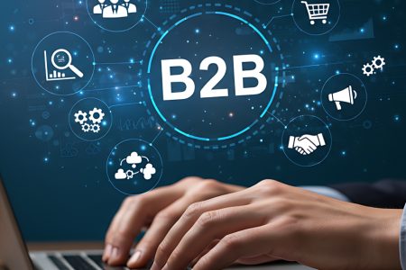 Hands typing on a laptop with B2B and digital connection icons overlaid